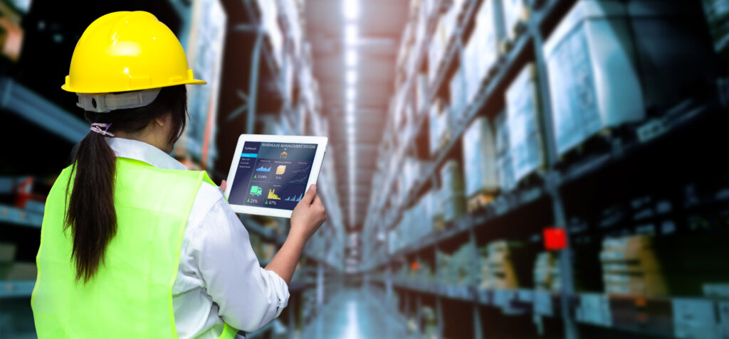 From Manual to Intelligent Supply Chain Management Logistics smart warehouse management systemworker hands holding tablet blurred warehouse as background