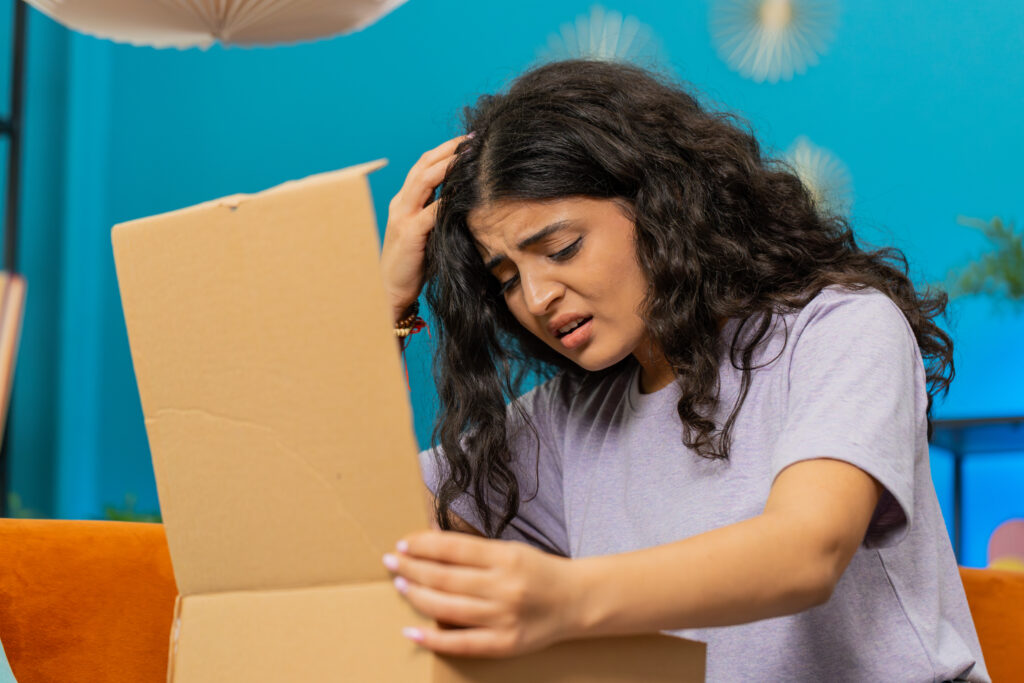angry dissatisfied shopper indian woman unpacking parcel feeling upset, confused, wrong delivery